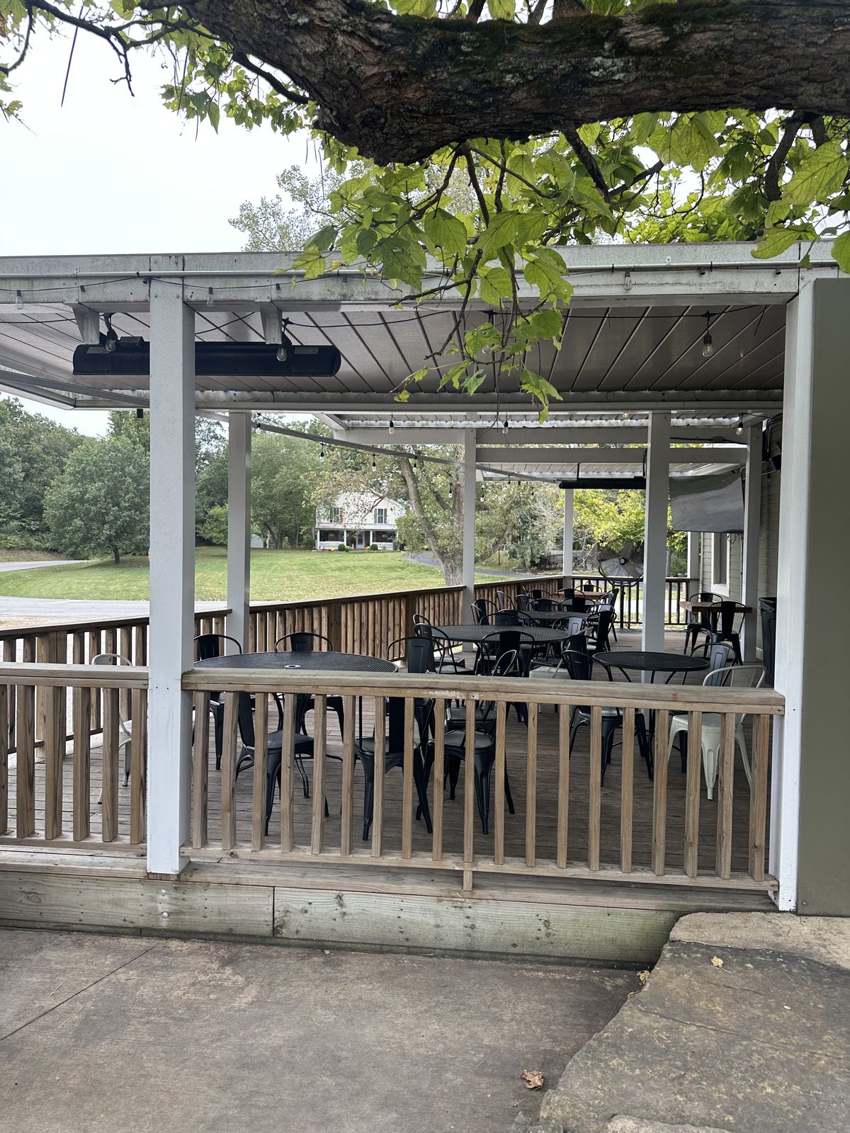 Exterior view under the covered porch framed by lush trees