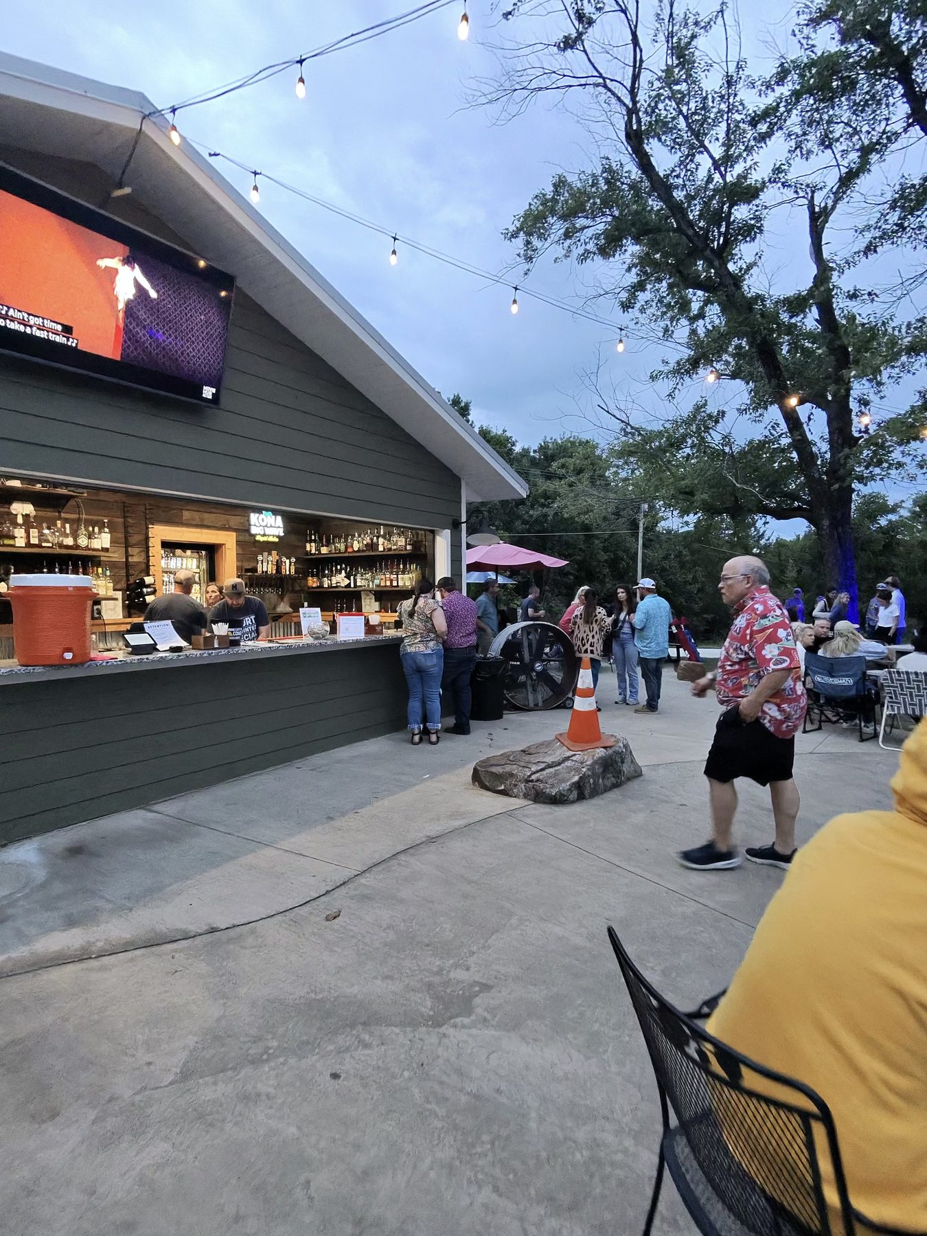 Guests gather around the outdoor bar as evening settles in